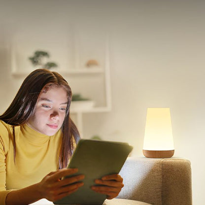 Lampe de chevet tactile étudiante qui lit un texte